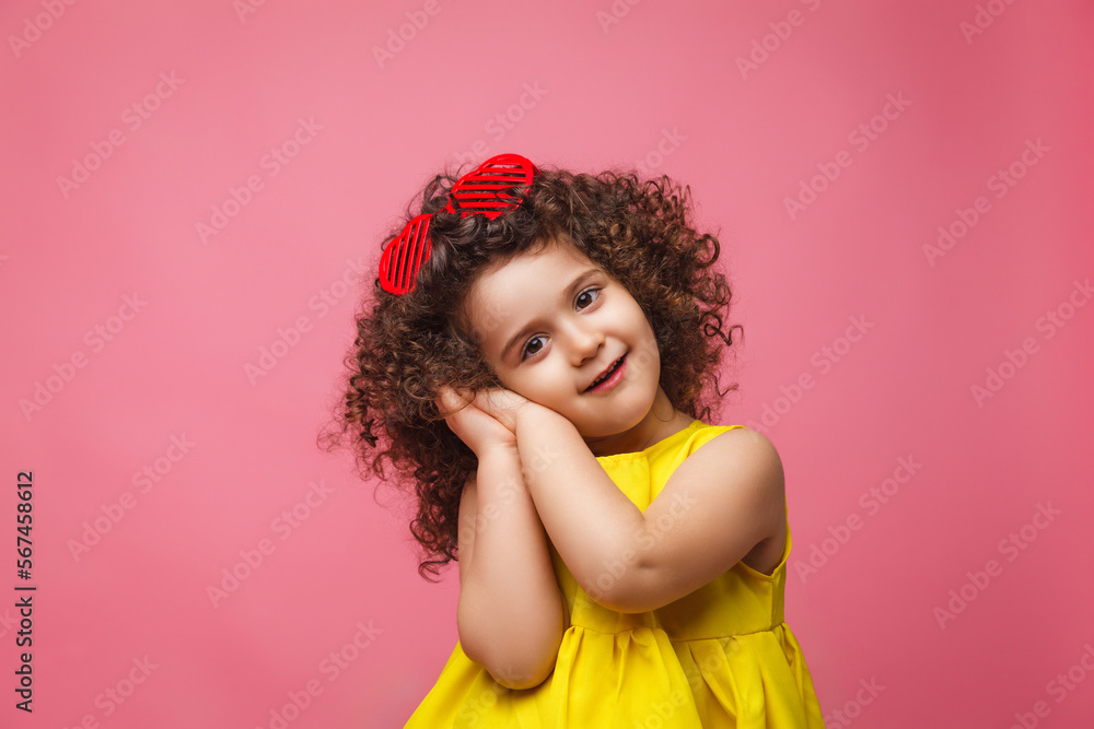 portrait of a girl in a yellow dress cute attractive cute cheerful cheerful little girl .isolated pink background. portrait of a girl in a yellow dress cute attractive cute cheerful cheerful little girl .isolated pink background.