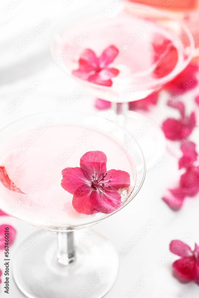 Romantic spring evening with rose champagne and flowers, two vintage coupes champagne glasses with beautiful soft flowers, selective focus. Rose drink concept, pastel colors Romantic spring evening with rose champagne and flowers, two vintage coupes champagne glasses with beautiful soft flowers, selective focus. Rose drink concept, pastel colors