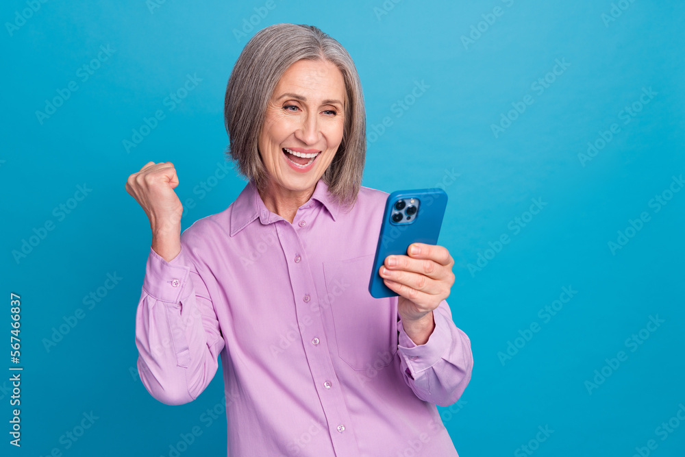 Photo of overjoyed positive lady wear trendy clothes use modern gadget device feel young isolated on blue color background Photo of overjoyed positive lady wear trendy clothes use modern gadget device feel young isolated on blue color background