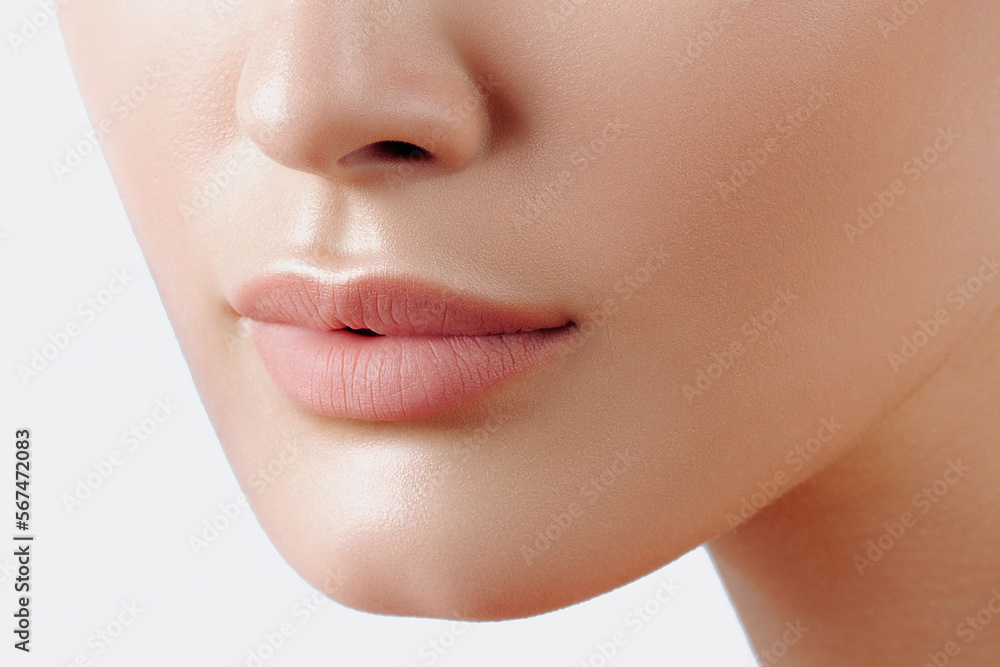 Obraz premium Lips of young beautiful woman closeup. Clean skin, nude makeup