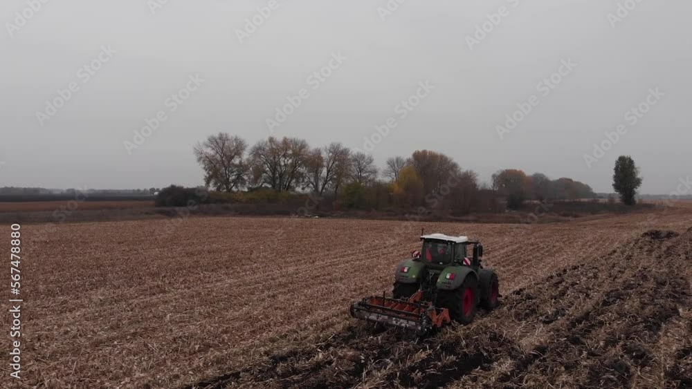 Tractor working in the field. Autumn tillage. Deep ripping with powerful tractor Tractor working in the field. Autumn tillage. Deep ripping with powerful tractor