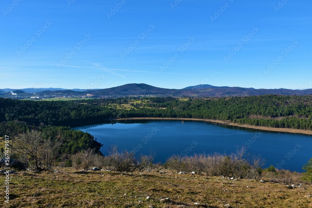 View of Petelinjsko jezero lake in Notranjska, Slovenia and the town of Pivka