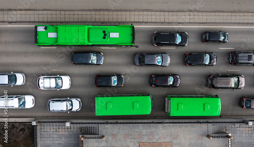 direct aerial view of the traffic on the roads. Congestion at a highway intersection. Top-down aerial drone flight Highway with busy city in the background and heavy traffic during rush hour.