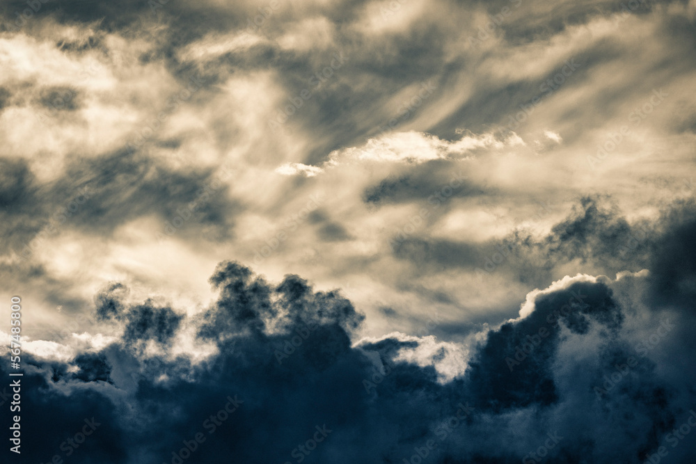 close up of fluffy light and dark cumulus clouds at sunset