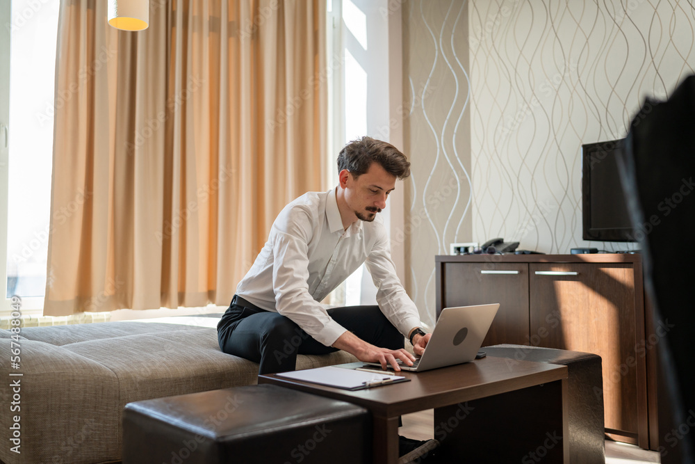 One man adult Caucasian male work on laptop computer from hotel room One man adult Caucasian male work on laptop computer from hotel room