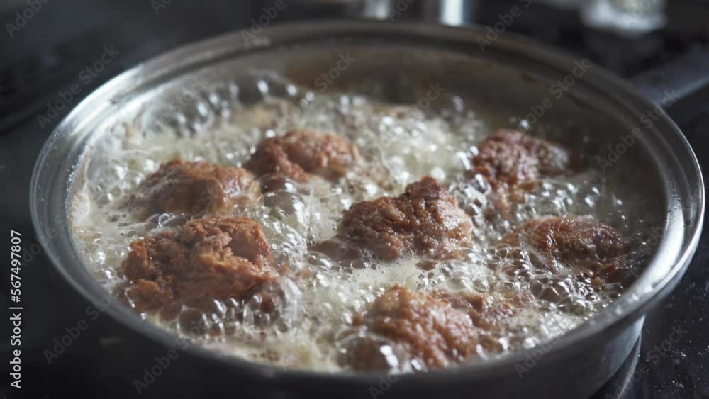 Pieces of breaded chicken are fried at a high temperature in a pan. Pieces of breaded chicken are fried at a high temperature in a pan.