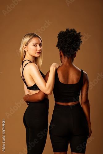 Beauty photography of two multiracial girls with natural skin posing in studio.