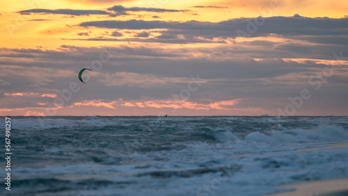 Person practicing kitesurfing in the sea, with a beautiful sunset in the background, in Castelldefels (Spain) © Fuentes RAW