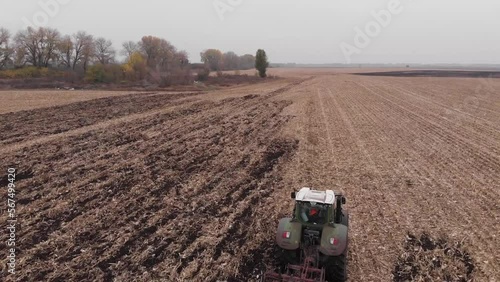 Tractor working in the field. Autumn tillage. Deep ripping with powerful tractor photo