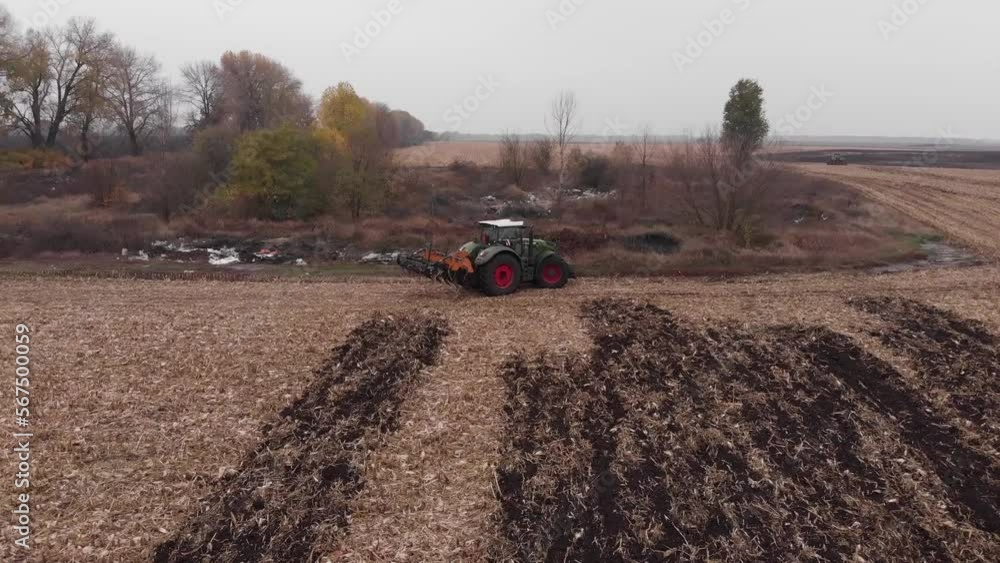 Tractor working in the field. Autumn tillage. Deep ripping with powerful tractor Tractor working in the field. Autumn tillage. Deep ripping with powerful tractor