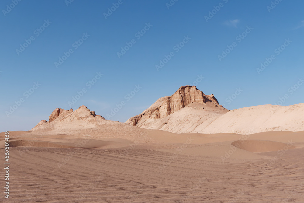 Low-angle view of the car trails in the sand and formations known as Kaluts in the background, Dasht-e Lut Desert, Iran Low-angle view of the car trails in the sand and formations known as Kaluts in the background, Dasht-e Lut Desert, Iran