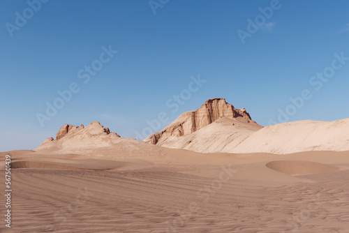 Low-angle view of the car trails in the sand and formations known as Kaluts in the background   Dasht-e Lut Desert  Iran 