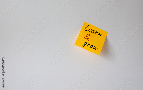 Learn and grow symbol. Concept words Learn and grow on orange steaky note. Beautiful white background. Business and Learn and grow concept. Copy space.