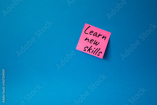 Learn new skills symbol. Concept words Learn new skills on pink steaky note. Beautiful blue background. Business and Learn new skills concept. Copy space. photo