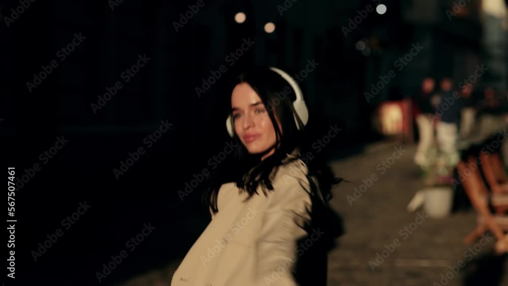 Young Beautiful dark-haired woman smiling happy using smartphone and headphones at the city Young Beautiful dark-haired woman smiling happy using smartphone and headphones at the city