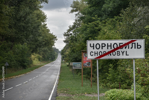 Sign on a road with the name of the city Chornobyl in Latin and Cyrillic. 