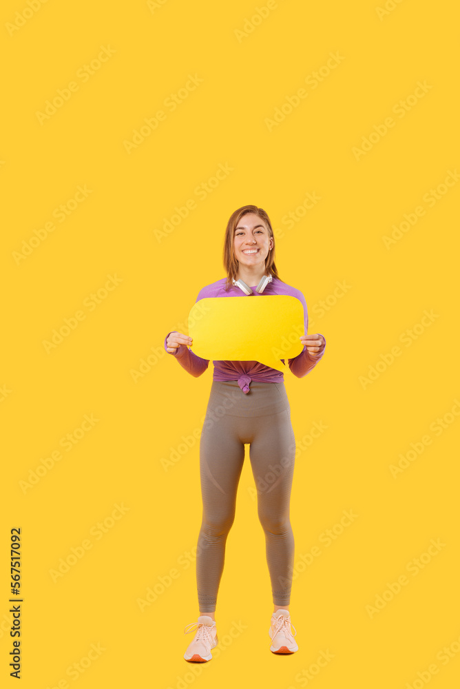 Full body photo of a young woman wearing sportswear holding a speech bubble. Full body photo of a young woman wearing sportswear holding a speech bubble.