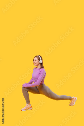 Vertical photo of a young woman performing lunges while listening to the music.