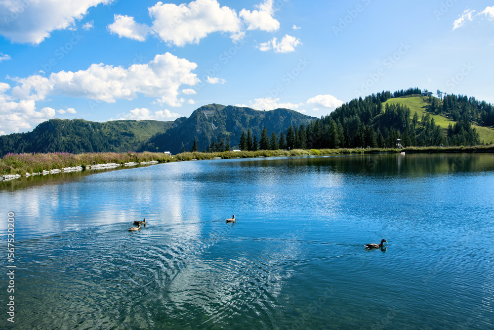 A lake in the Austrian Alps surrounded by mountains on the Grafenberg hill near the town of Wagrain. A lake in the Austrian Alps surrounded by mountains on the Grafenberg hill near the town of Wagrain.