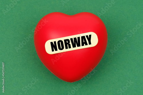 On a green surface lies a red heart with the inscription - Norway