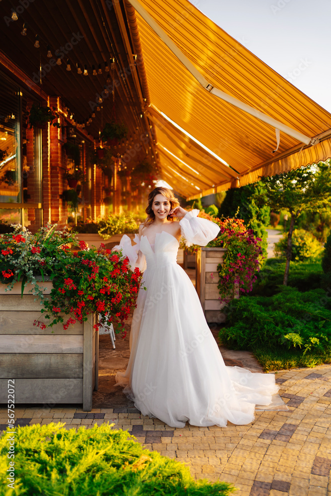 Fototapeta premium beautiful bride in a white delicate dress on the terrace of the restaurant