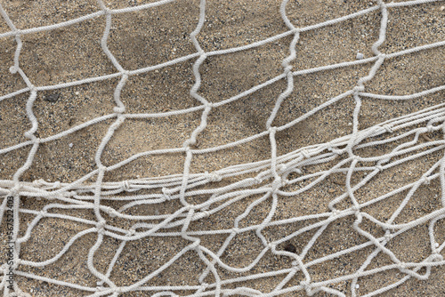 Openwork net on wet dark sand. Openwork. Woven mesh texture. High quality photo