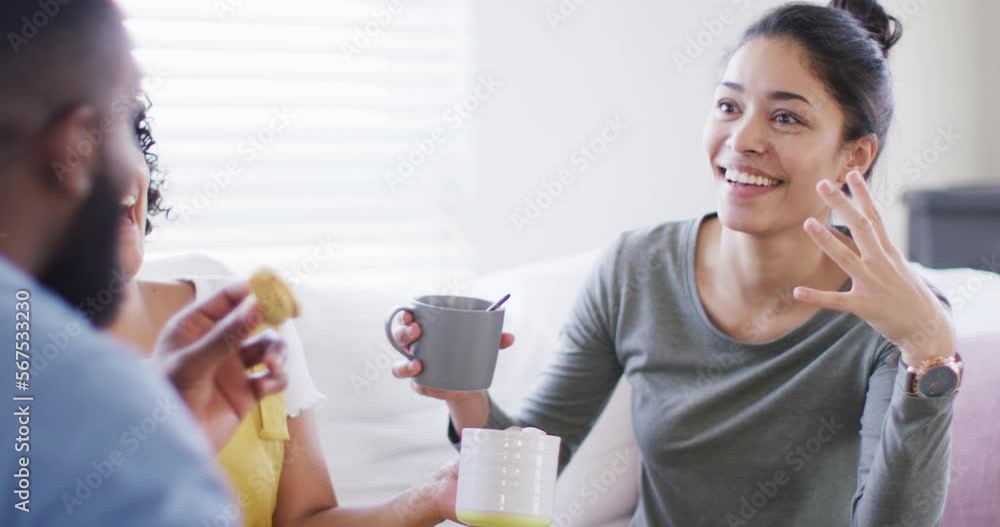 Diverse male and female friends talking and having tea at home in slow motion Diverse male and female friends talking and having tea at home in slow motion