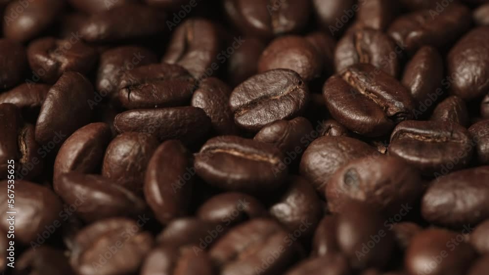 Background of roasted coffee beans. Many fried coffee grains are poured on top. Selective focus. The concept of an advertising banner for a coffee shop or commodity production. Background of roasted coffee beans. Many fried coffee grains are poured on top. Selective focus. The concept of an advertising banner for a coffee shop or commodity production.