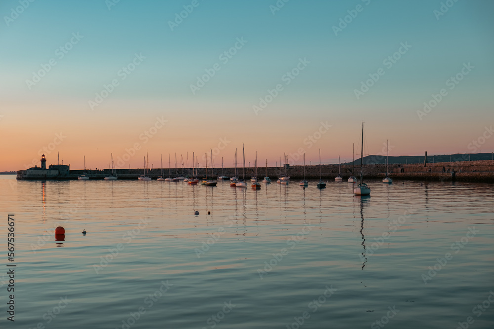 Silhouettes of boats during blue hour with Dun Laoghaire lighthouse in the background, Dublin, Ireland