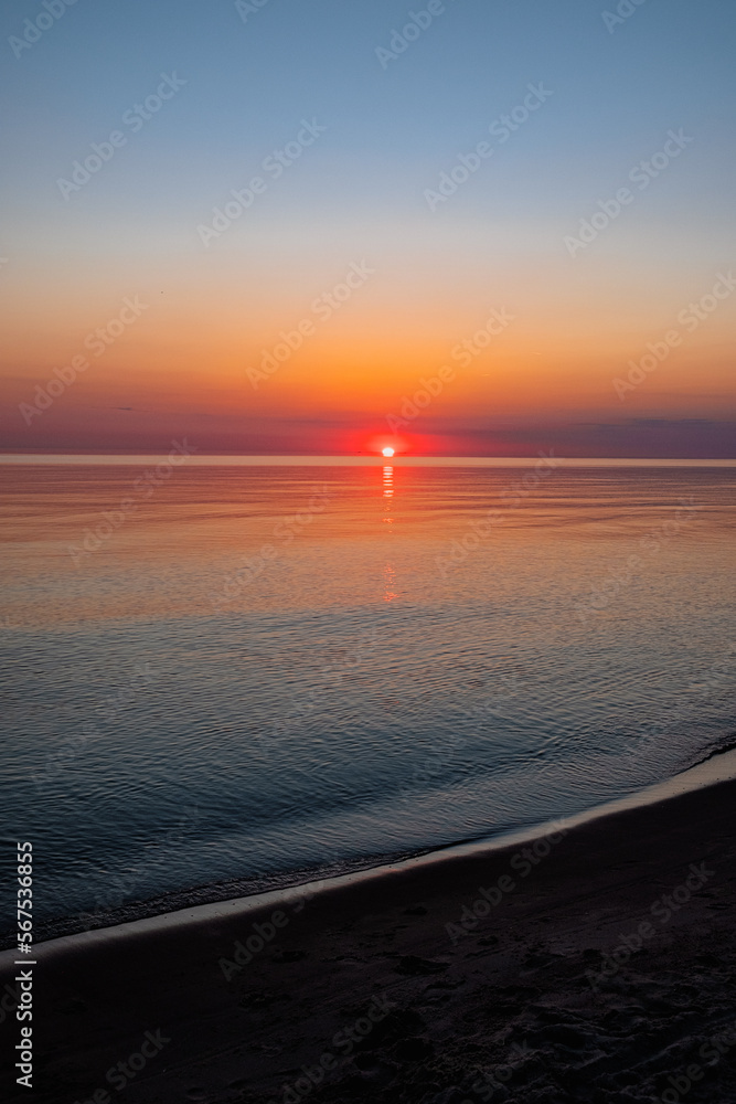 A perfect sunset into the sea, clear skies, soft colours, no people