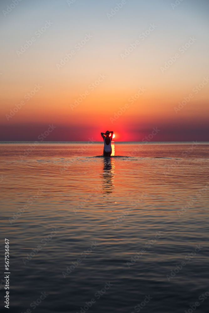 Silhouette of a woman walking into the sunset, Baltic sea, Lithuania