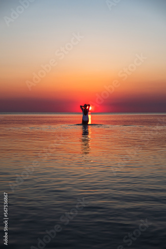 Silhouette of a woman walking into the sunset, Baltic sea, Lithuania photo