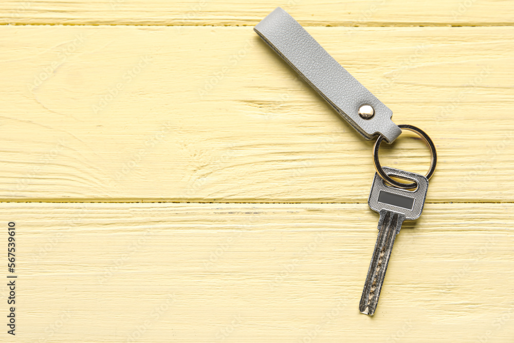 Key with leather keychain on color wooden background Key with leather keychain on color wooden background