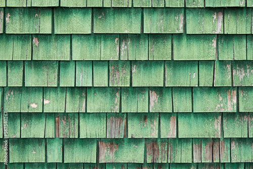 Aged and weathered green painted wood roof shingles.