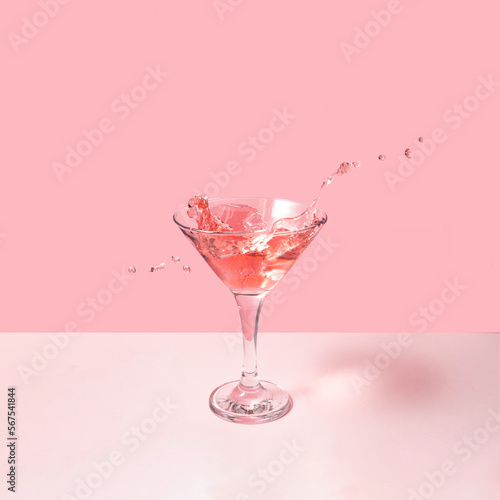 Tasty cocktail on pastel light pink background. Creative drink concept. Minimalistic beverage composition.