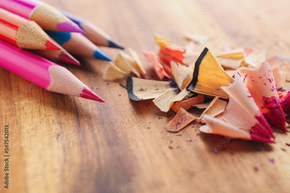 Colorful pencils with shavings on wooden table, closeup Colorful pencils with shavings on wooden table, closeup