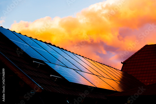 the sunset paints the sky red, reflecting off the shiny solar panels