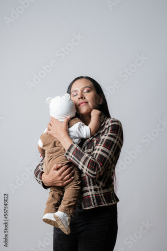 Young mother holding her baby. Latin American mom with baby. Mother\'s Love. Baby smiling. Single mother and her son. Single mother with her son in her arms. Simple family mother and son.