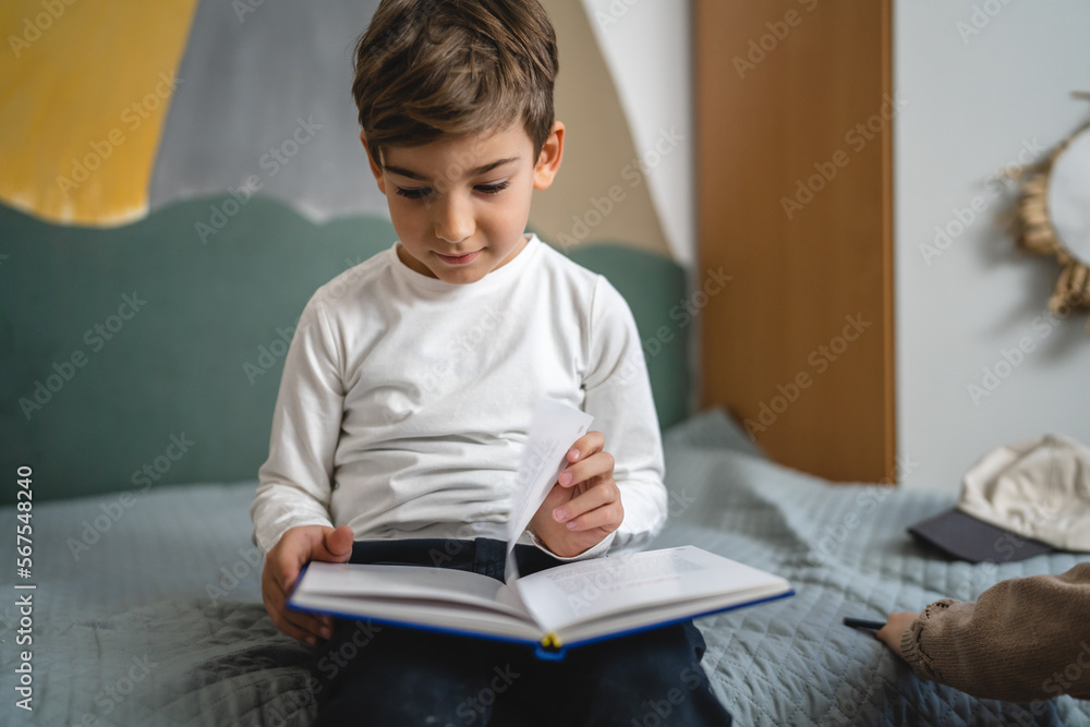 One boy caucasian child six years old kid in room at home read book One boy caucasian child six years old kid in room at home read book