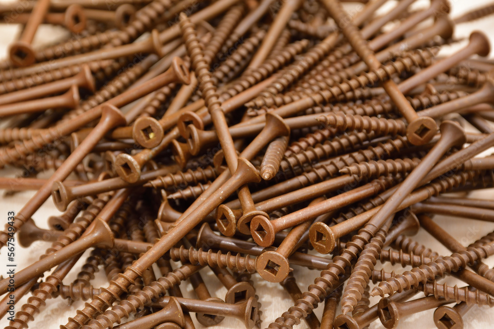 Ceramic coated brown flat head wood screws. Square head outdoor screws. Robertson deck screws. Pile of coarse thread wood screws. - obrazy, fototapety, plakaty 
