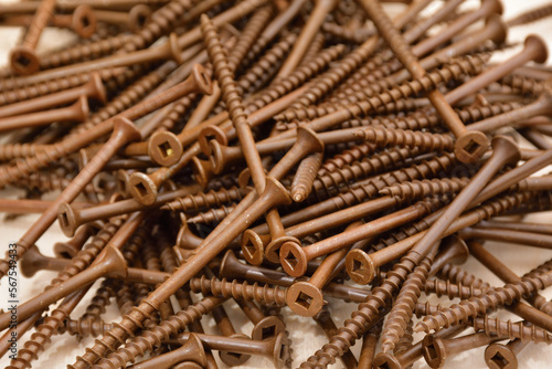 Ceramic coated brown flat head wood screws. Square head outdoor screws. Robertson deck screws. Pile of coarse thread wood screws.