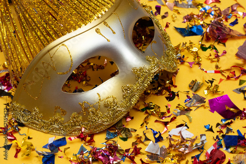 colorful carnival mask on the yellow background with several ornaments