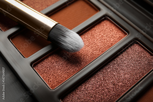 Beautiful eye shadow palette and brush as background, closeup