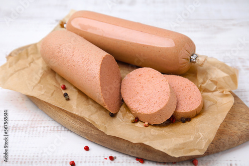 Board with delicious liver sausage on white wooden table, closeup