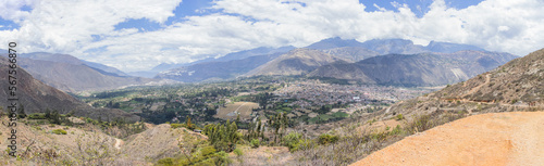 Panoramic photo of the houses of Caraz, with views of several mountains, diverse vegetation and a bright sun. On the road to Pavas, Caraz, Ancash - Peru. South America