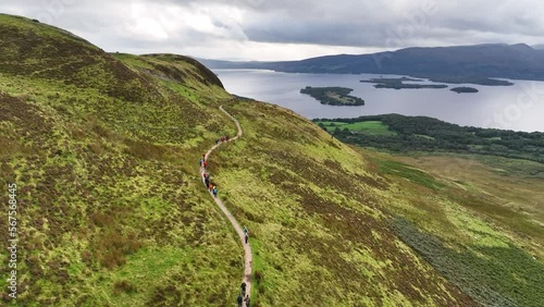 Cinematic Aerial Sweep of Hillwalkers Climbing Conic Hill. Loch Lomond, Scotland photo