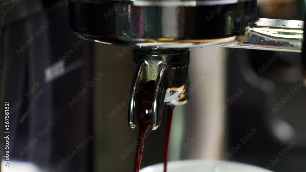 CU SLOW MOTION Espresso Pouring out of porta filter spout. Coffee pouring out of Coffee Machine. CU SLOW MOTION Espresso Pouring out of porta filter spout. Coffee pouring out of Coffee Machine.