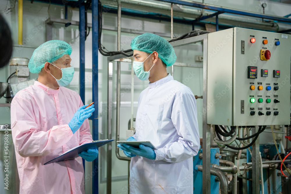 Obraz premium A quality supervisor or food or pharmaceutical technician discuss about process control of food and drugs before send product to the customer. Production leader recheck parameter and productivity.