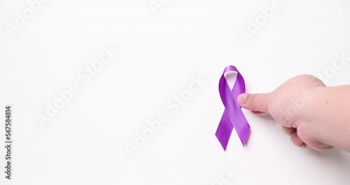 Detail of a male hand holding a light purple ribbon on a white background. Cause ribbons. photo