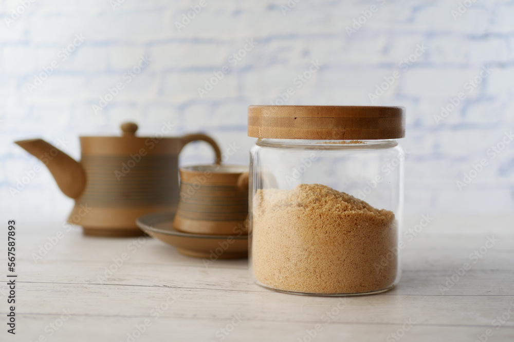 coconut sugar in jar and a tea cup on table coconut sugar in jar and a tea cup on table